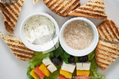 Image of toast with cheese vegetables and olive on the stick