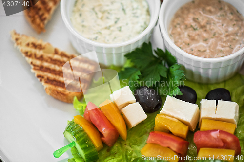 Image of toast with cheese vegetables and olive on the stick