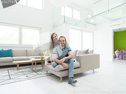 Image of young handsome couple hugging on the sofa