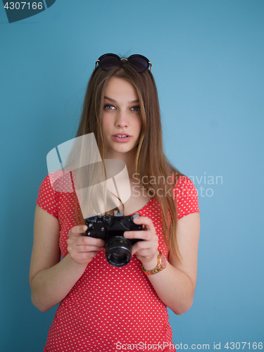 Image of beautiful girl taking photo on a retro camera