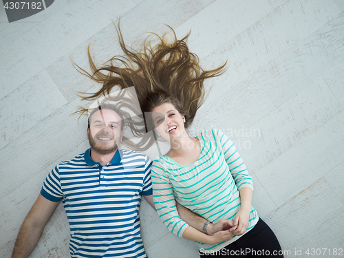 Image of handsome couple lying on floor