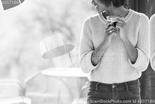 Image of Young black girl standing and drinking coffe closeup