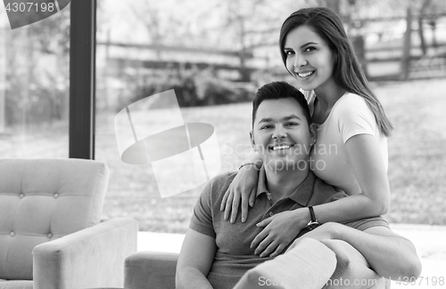 Image of Two cheerful lovers sitting on the couch