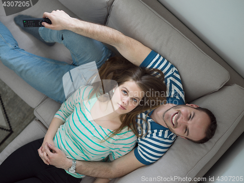 Image of young handsome couple hugging on the sofa