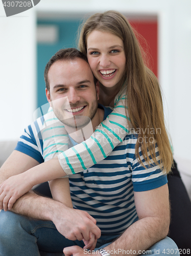 Image of young handsome couple hugging on the sofa