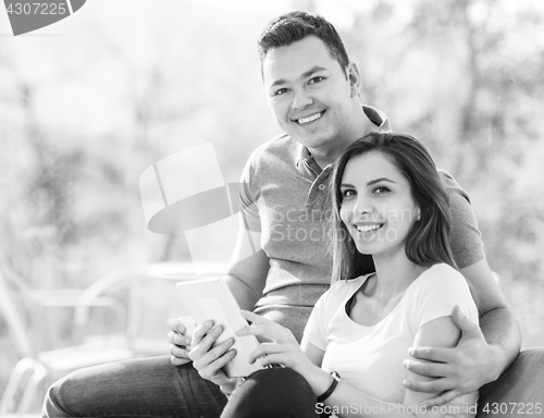 Image of Two cheerful lovers sitting on the couch