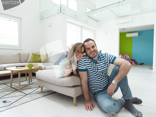 Image of young handsome couple hugging on the sofa