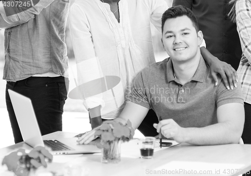 Image of Young businessman with his team