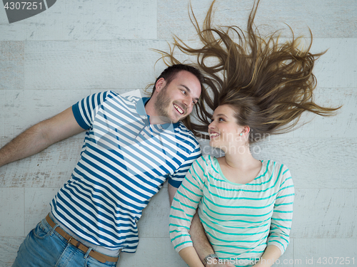 Image of handsome couple lying on floor