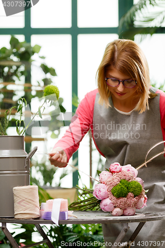 Image of Woman florist. Focused on flowers