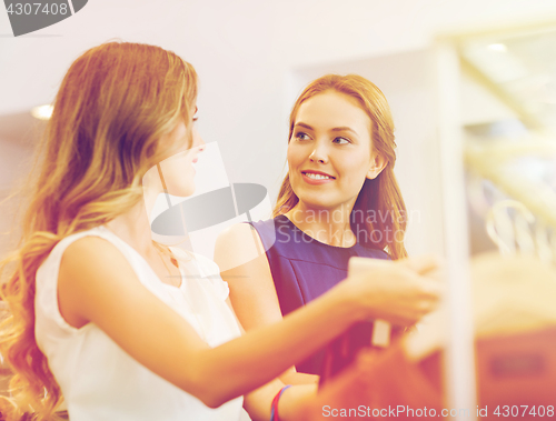 Image of happy women with shopping bags at clothing shop