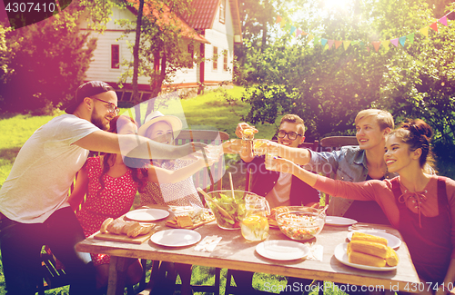 Image of happy friends having party at summer garden