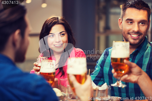 Image of friends dining and drinking beer at restaurant