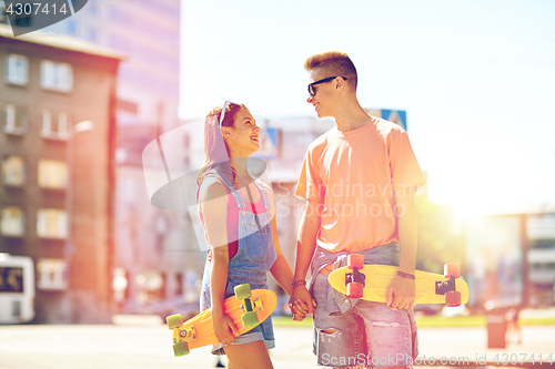 Image of teenage couple with skateboards on city street