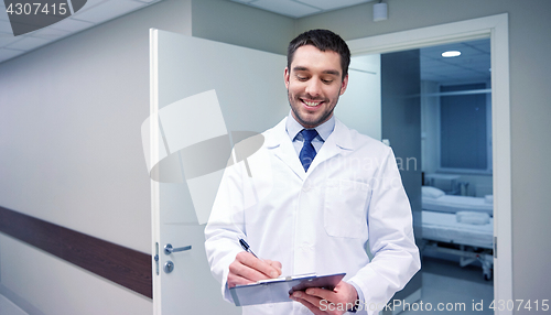 Image of smiling doctor with clipboard at hospital