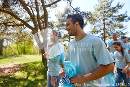 Image of volunteers with garbage bags walking outdoors