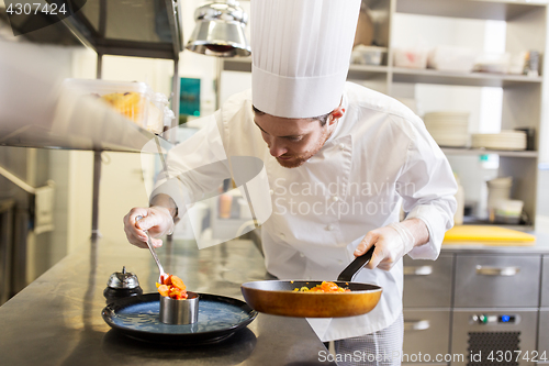 Image of happy male chef cooking food at restaurant kitchen