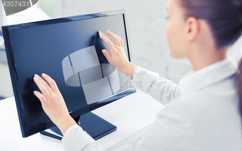 Image of smiling businesswoman with touchscreen in office