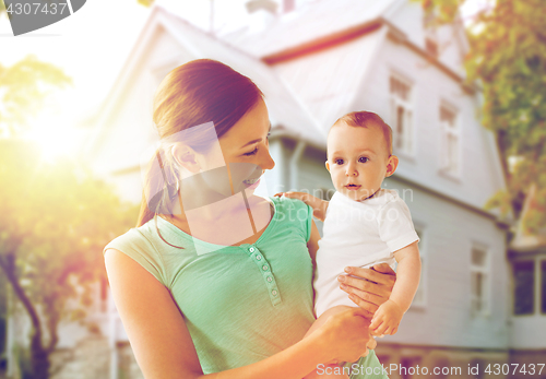 Image of happy young mother with baby over holidays lights