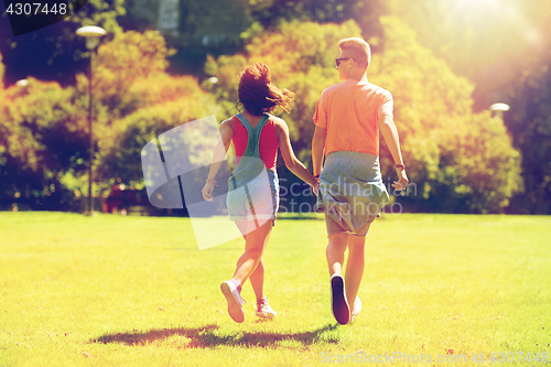 Image of happy teenage couple walking at summer park