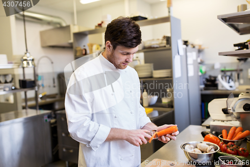 Image of happy male chef cooking food at restaurant kitchen