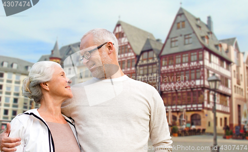 Image of senior couple hugging over frankfurt background