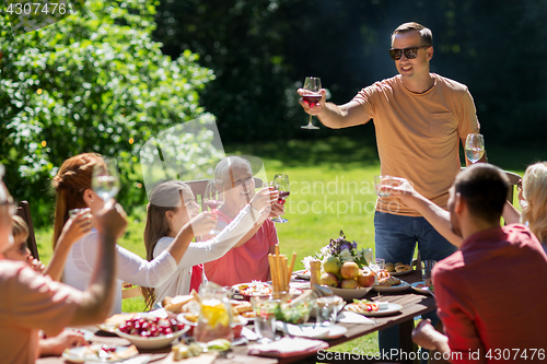 Image of happy family having dinner or summer garden party