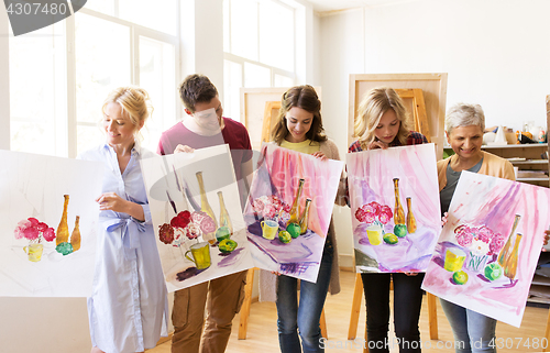 Image of group of artists with pictures at art school