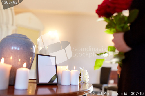 Image of cremation urn and woman at funeral in church