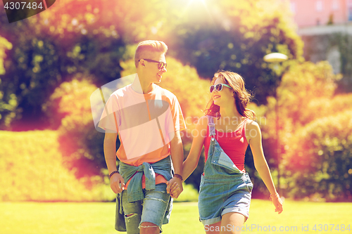 Image of happy teenage couple walking at summer park