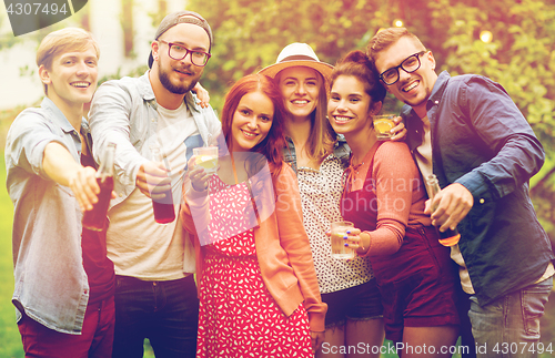 Image of happy friends with drinks at summer garden party