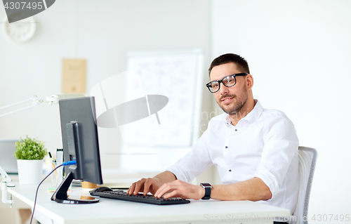 Image of businessman typing on computer keyboard at office