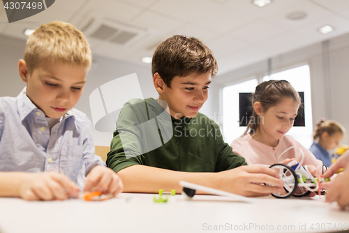 Image of happy children building robots at robotics school