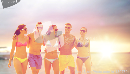 Image of smiling friends in sunglasses on summer beach