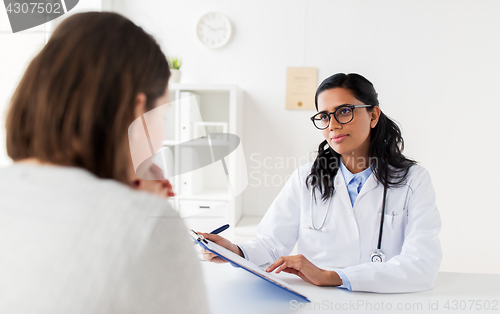 Image of doctor with clipboard and woman patient at clinic