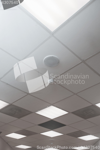 Image of Office room ceiling with smoke detector and alarm