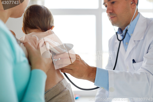 Image of doctor with stethoscope listening baby at clinic