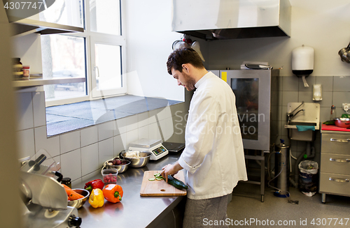 Image of happy male chef cooking food at restaurant kitchen