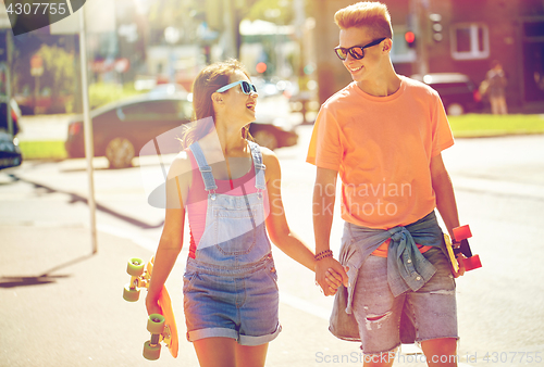 Image of teenage couple with skateboards on city street