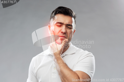 Image of unhappy man suffering toothache