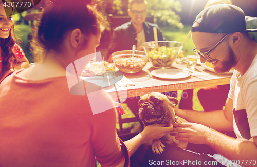 Image of happy friends having dinner at summer garden party