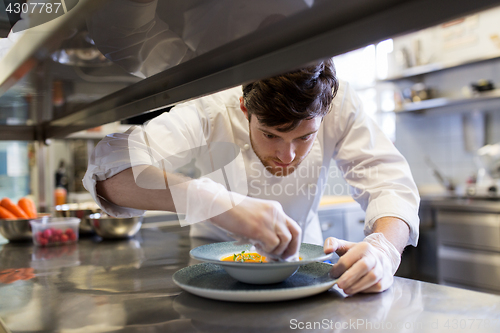 Image of happy male chef cooking food at restaurant kitchen