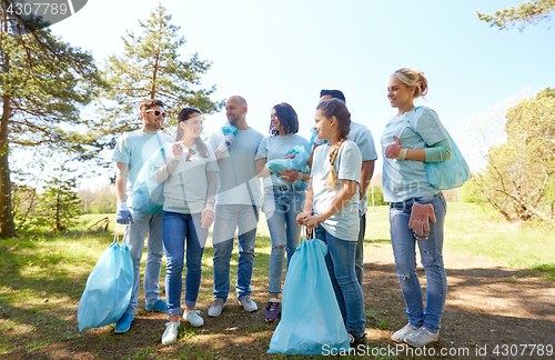 Image of volunteers with garbage bags walking outdoors