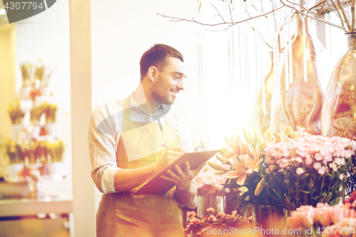 Image of florist man with clipboard at flower shop