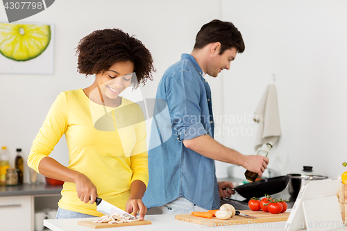 Image of happy couple cooking food at home kitchen