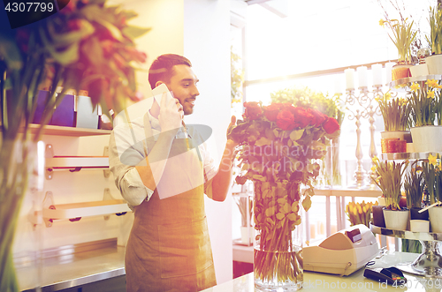 Image of man with smartphone and red roses at flower shop