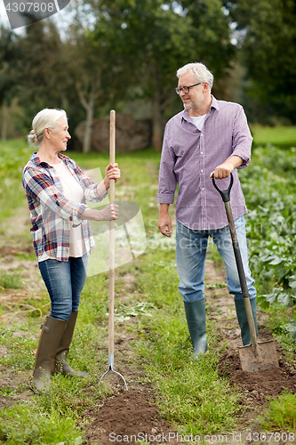 Image of senior couple with shovels at garden or farm