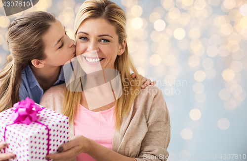 Image of girl giving birthday present to mother over lights