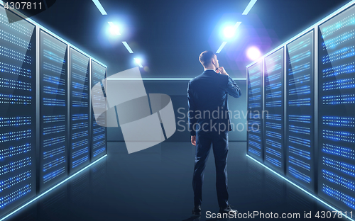 Image of businessman over server room background