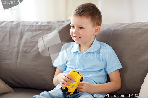 Image of happy little boy with toy car at home